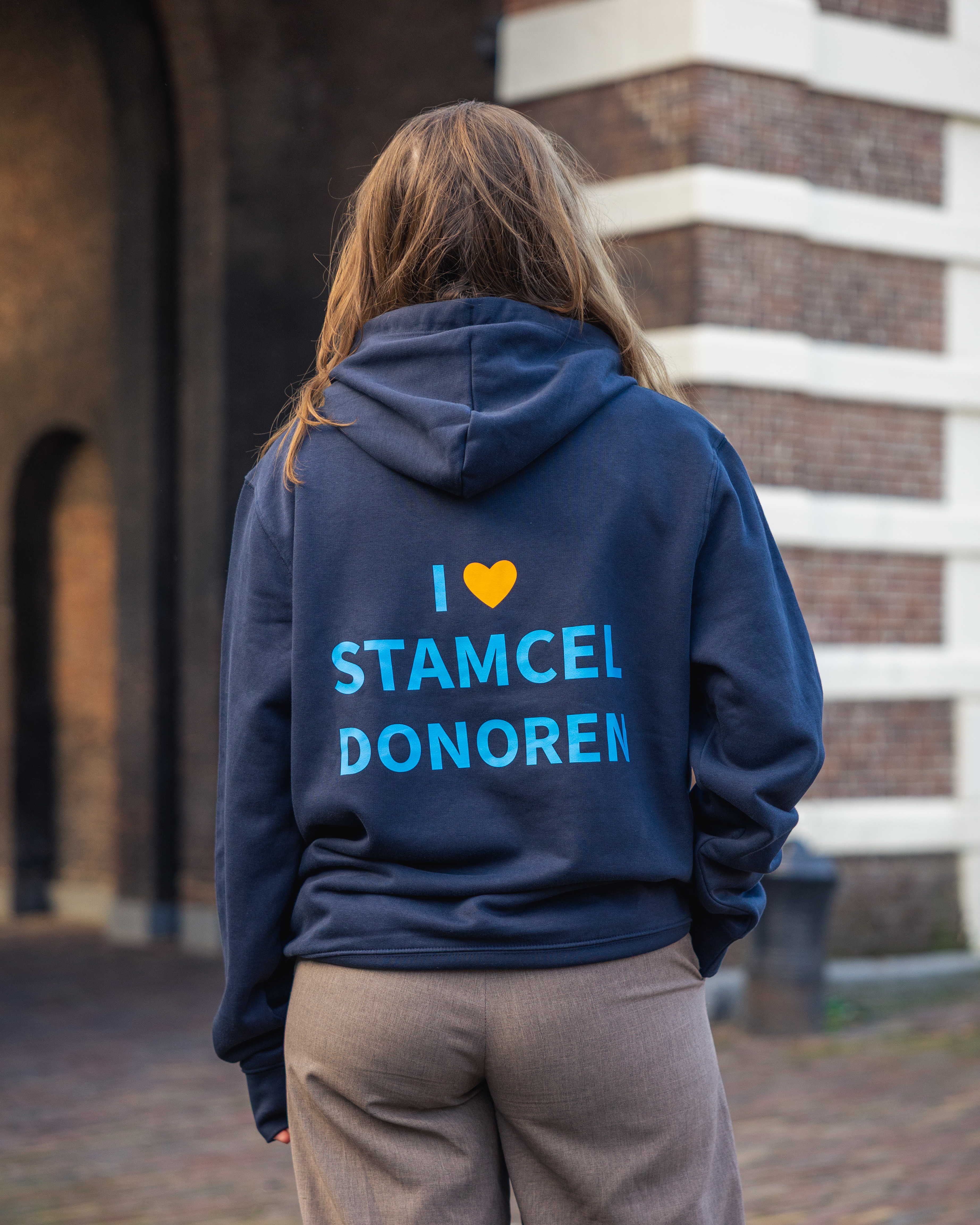 Maxime met haar rug naar ons toe in donkerblauwe Matchis trui