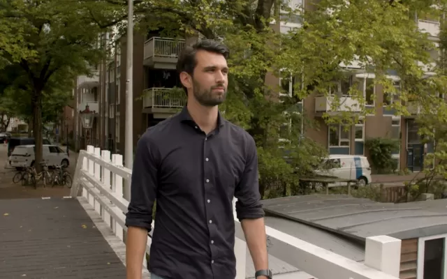 Marc van der Meij van AbbVie loopt buiten op een brug 