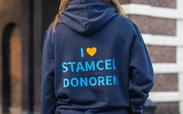 Maxime met haar rug naar ons toe in donkerblauwe Matchis trui