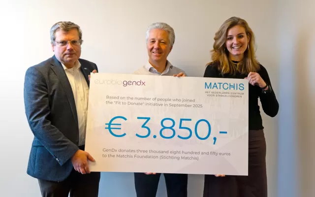 Bert en twee medewerkers van GenDx houden een cheque voor Matchis vast
